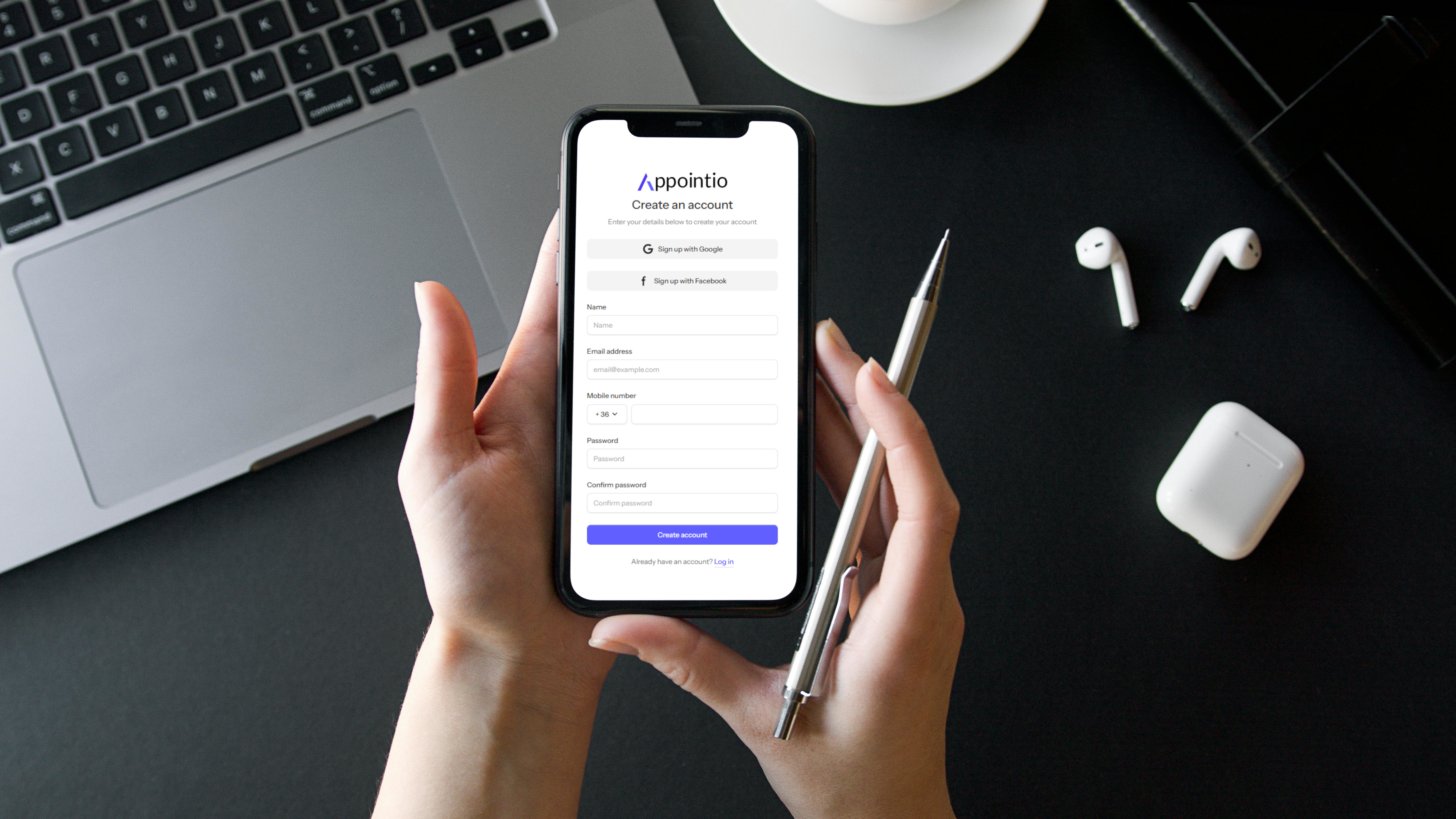 Hand holding a phone with the login page of appointio